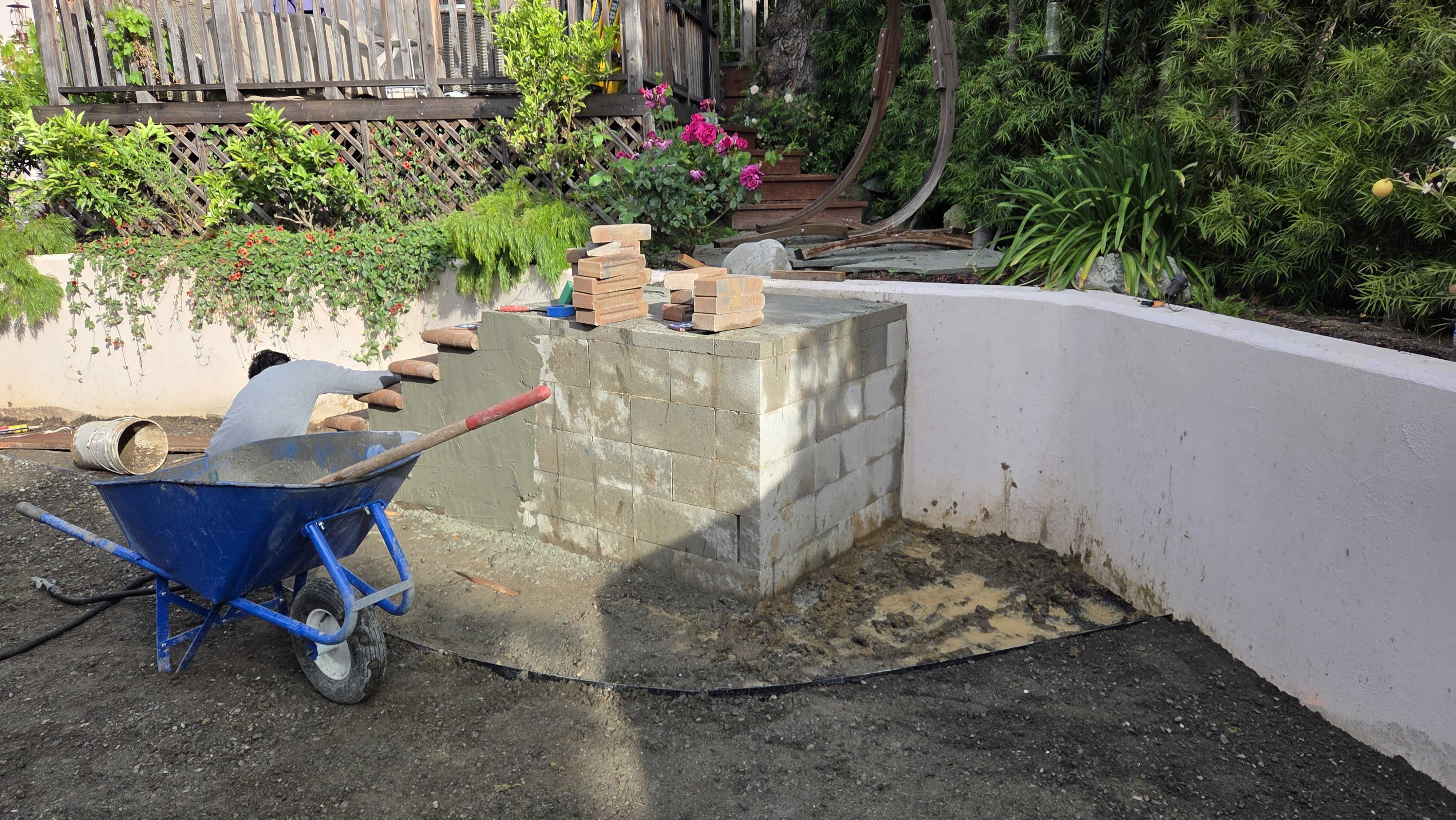 Backyard patio under construction showing a concrete block base/core being built on a compacted aggregate sub-base with...