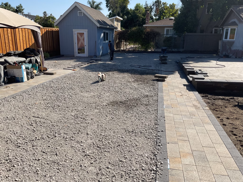 Base rock and paver installation progress.