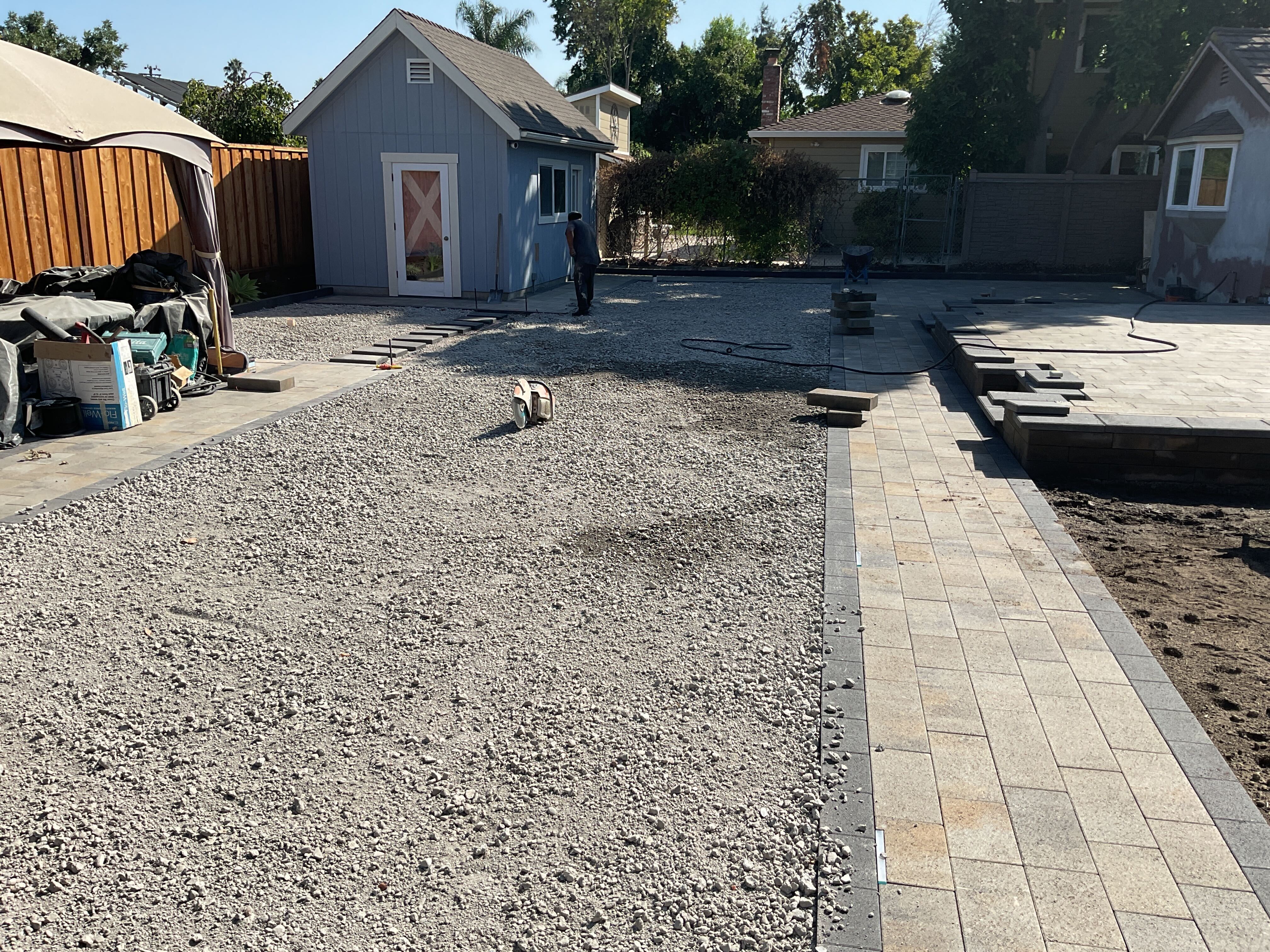 Base rock and paver installation progress.