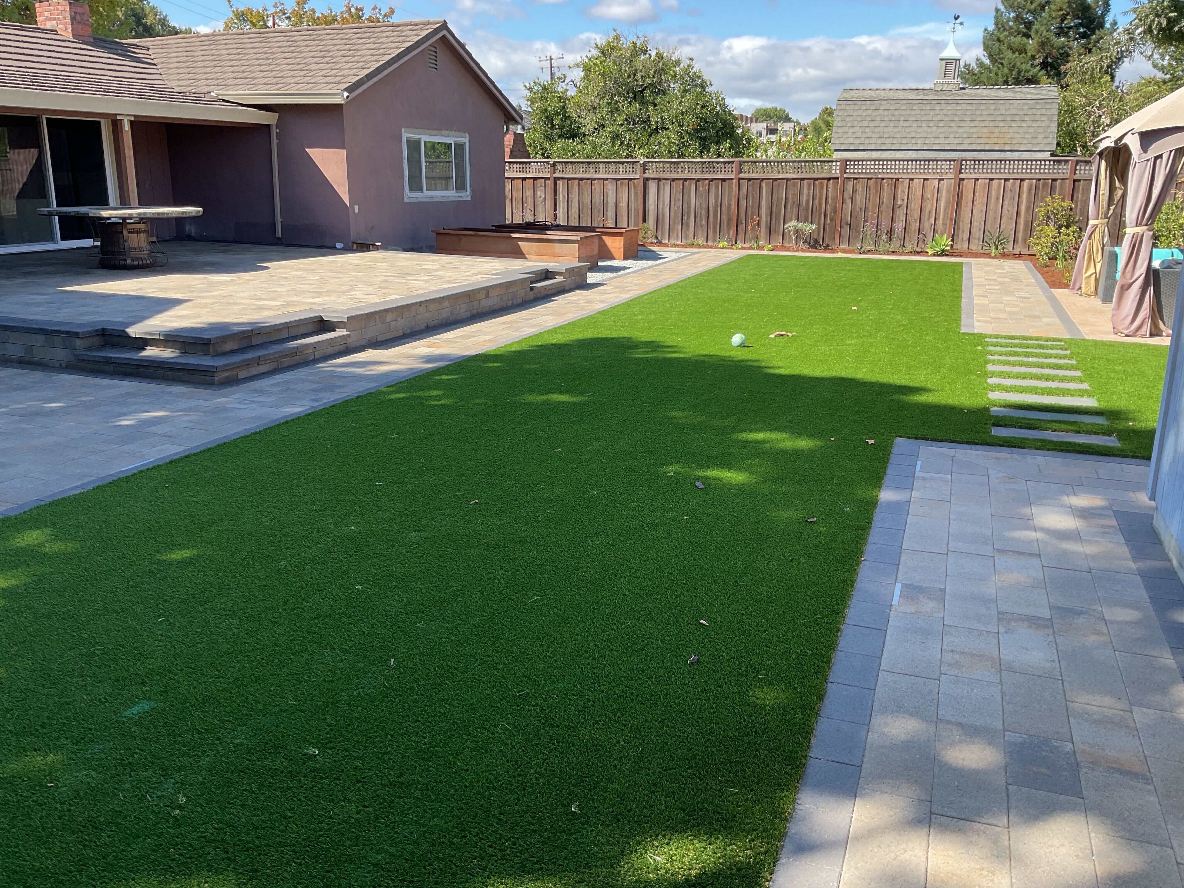 Best hero: broad finished turf, pavers, raised edges, and house context.