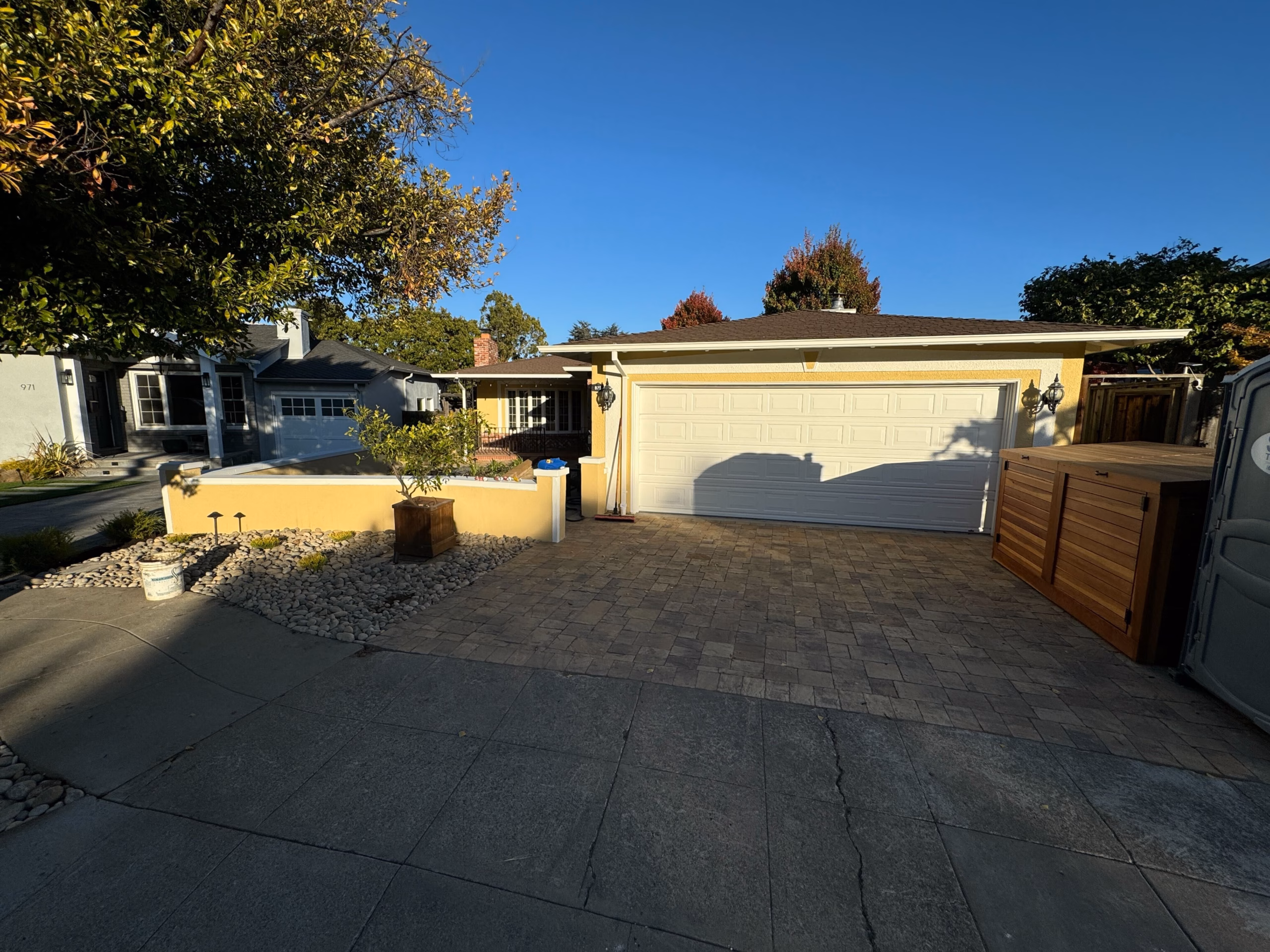 Finished paver driveway beside a new planter wall in a San Mateo front yard.