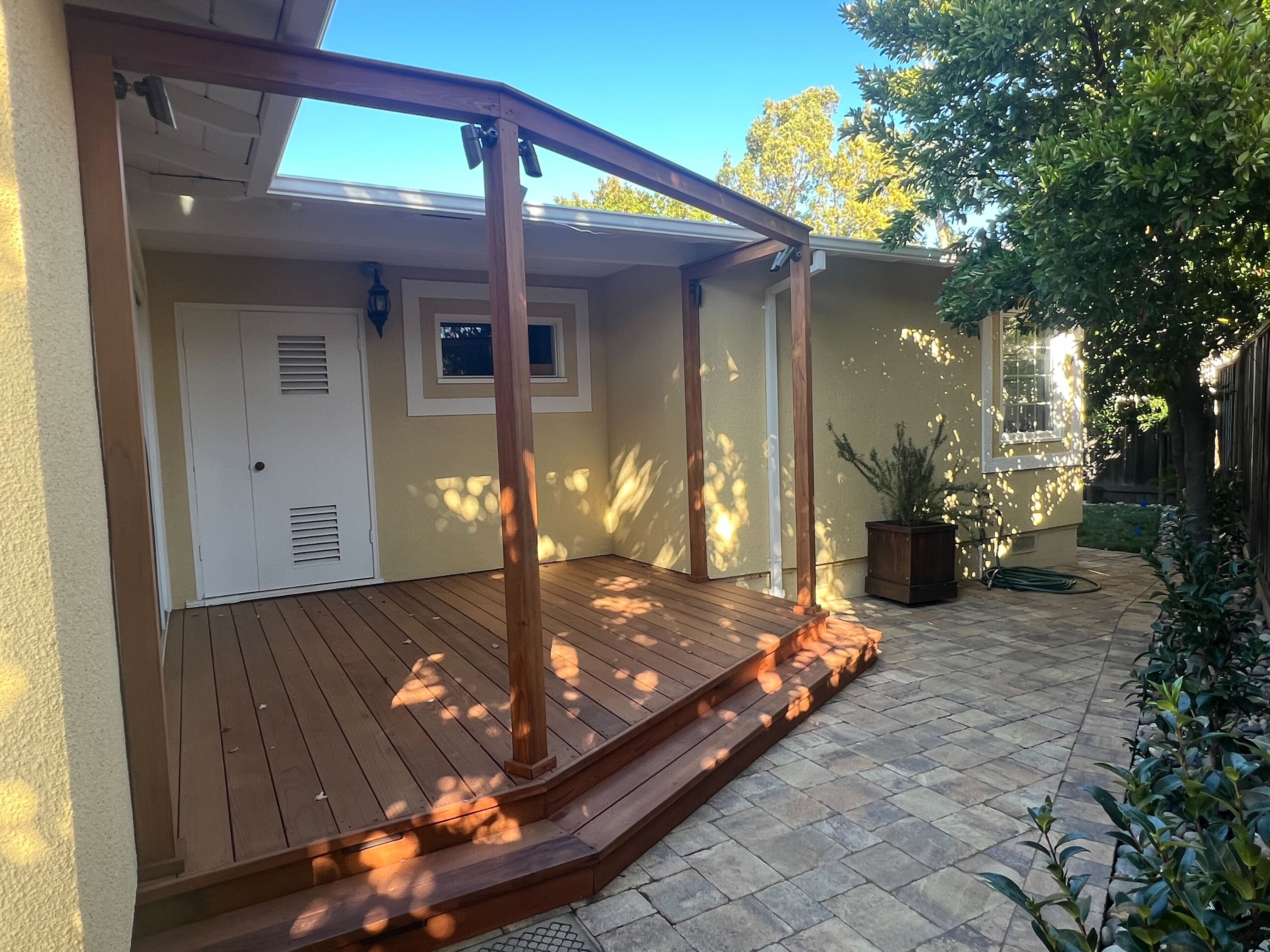 Finished rear patio/deck walkout view; clear completed hardscape.