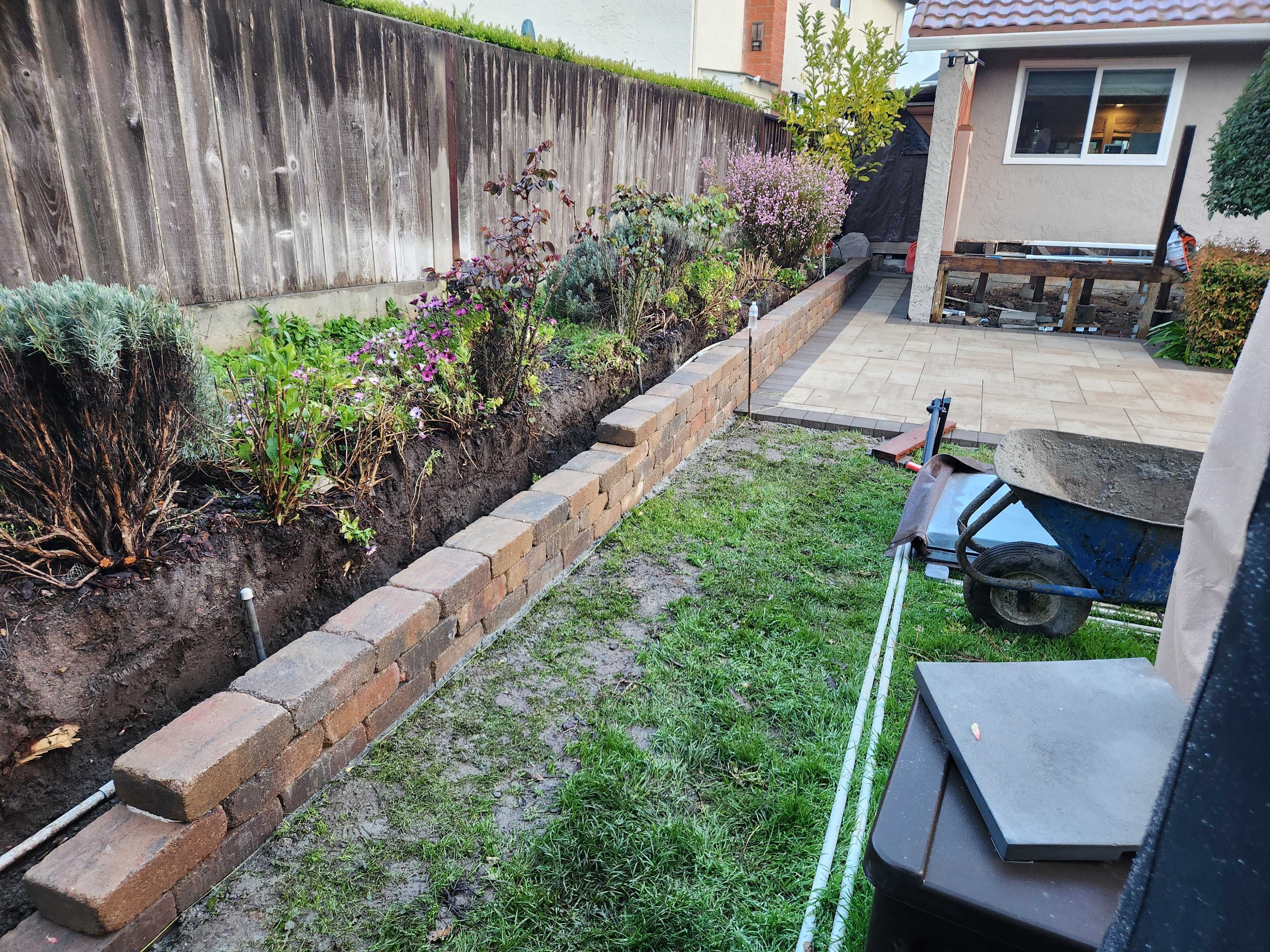 Segmental retaining wall going up along the patio perimeter