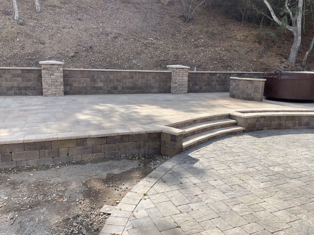 Multi-level paver patio with curved bullnose stone steps and segmental retaining wall