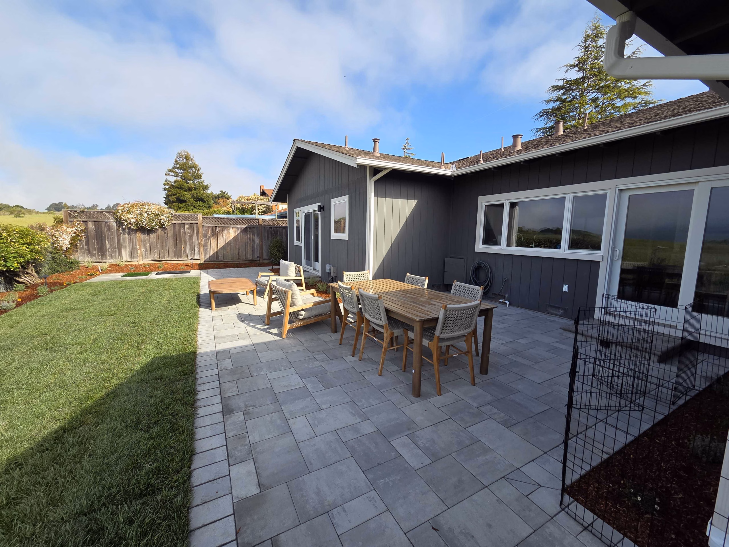 Large-format paver patio with an outdoor dining set beside a lawn in San Carlos, CA