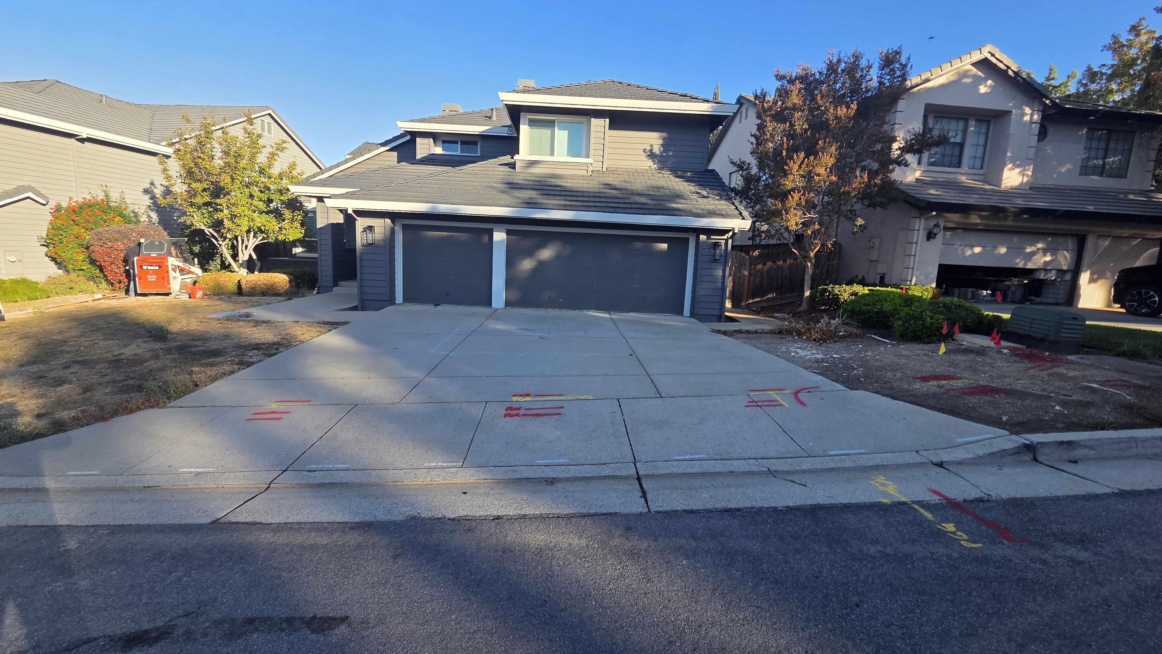 The Morgan Hill home before the remodel, with a plain concrete driveway, dry lawn, and utility survey markings.