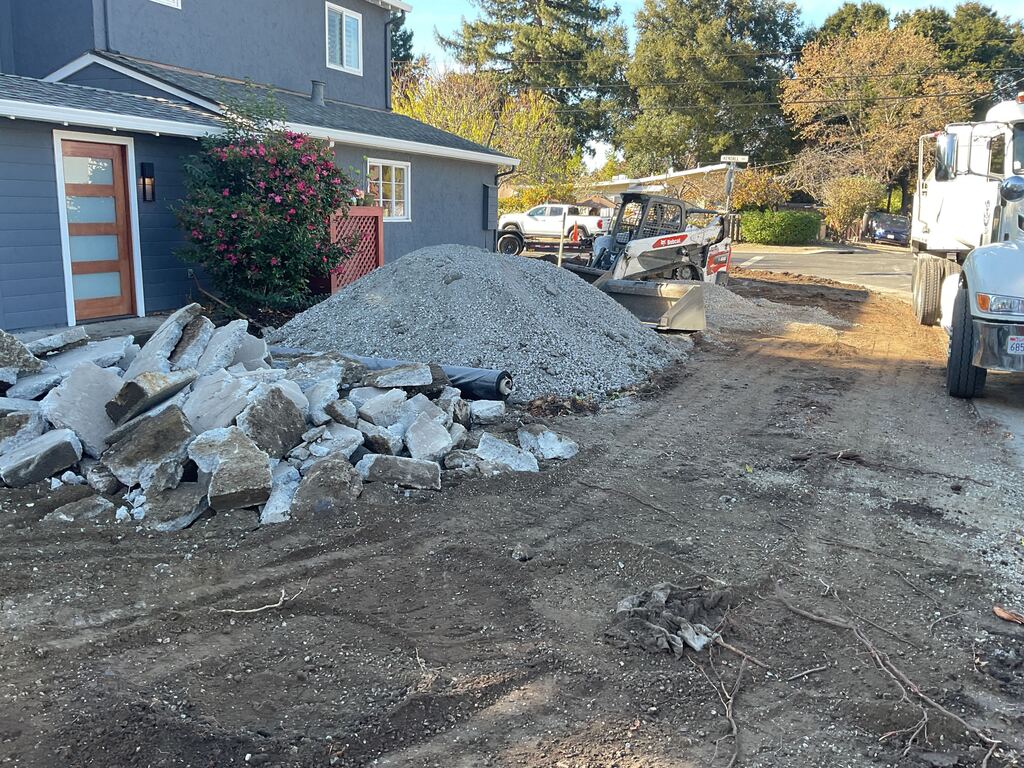 Front driveway demolition and site prep at a residential property. Large pile of broken concrete and a separate...