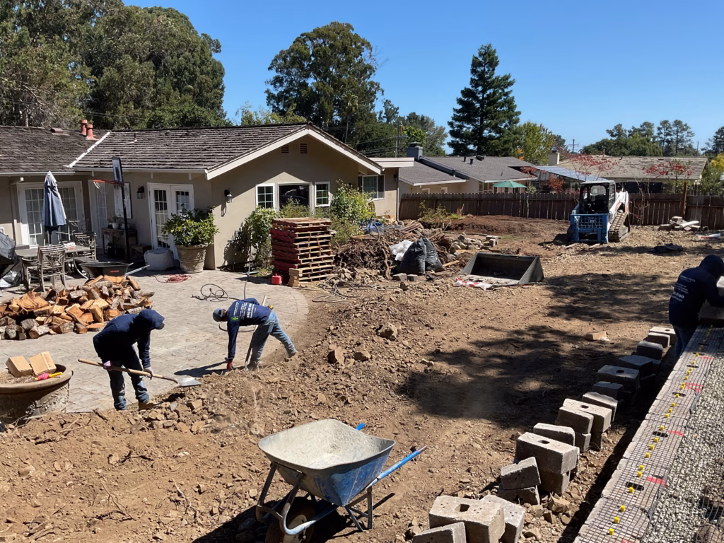 Crew hand-grading the sloped backyard during excavation