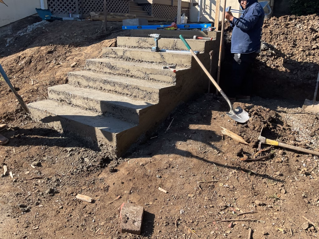Freshly poured concrete steps taking shape and checked for level before the paver treads are set.