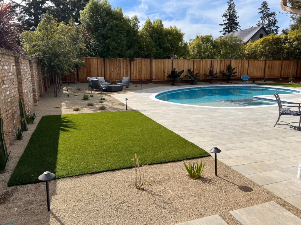 After — synthetic turf panel, decomposed granite planting and path lights along the same brick wall in Los Altos, CA