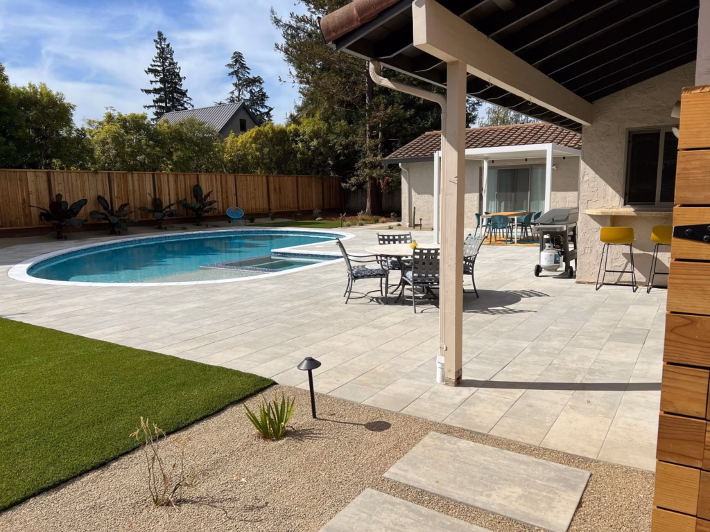 Pool and paver deck seen from under the patio cover in Los Altos, CA