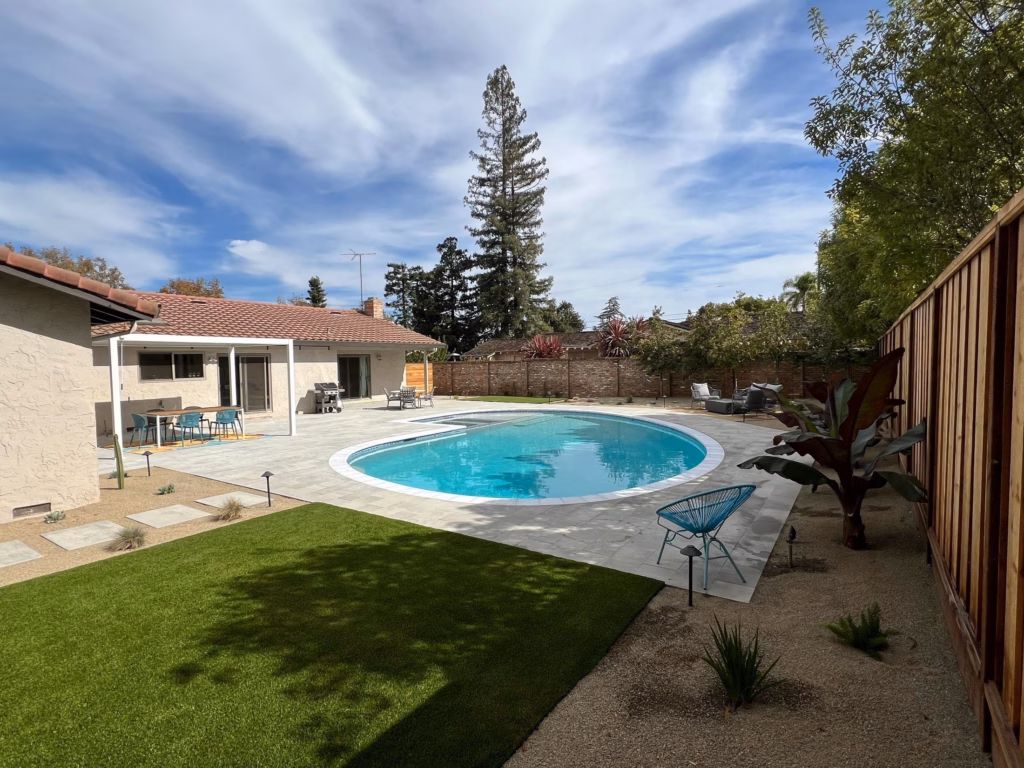 Wide view of turf lawn, paver deck, pool and redwood privacy screen in Los Altos, CA