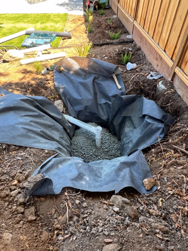Dry well pit with filter fabric and drain rock during drainage installation in Los Altos, CA