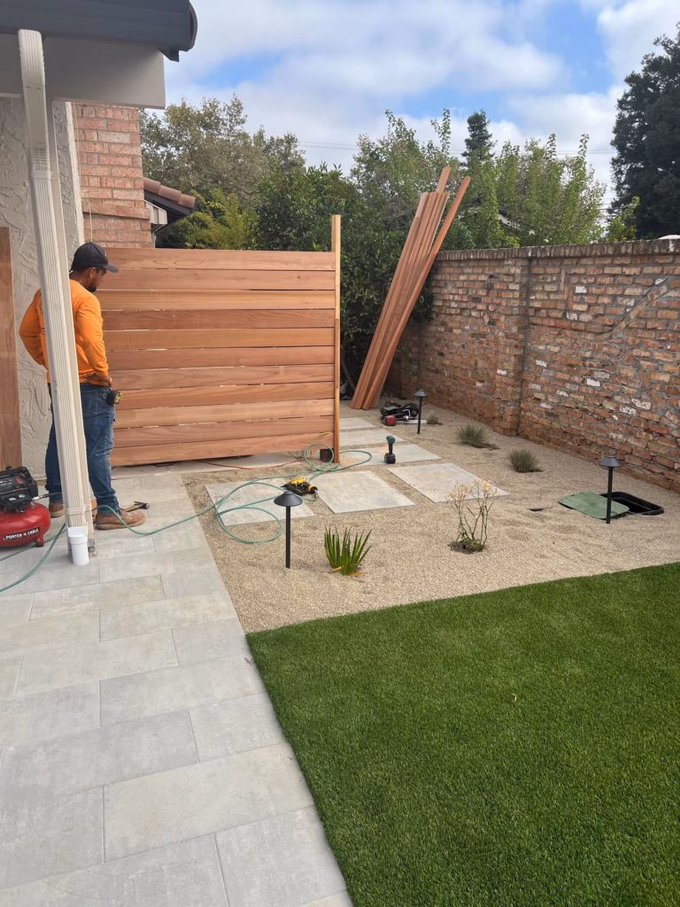 Redwood privacy screen being installed against the reclaimed brick wall in Los Altos, CA