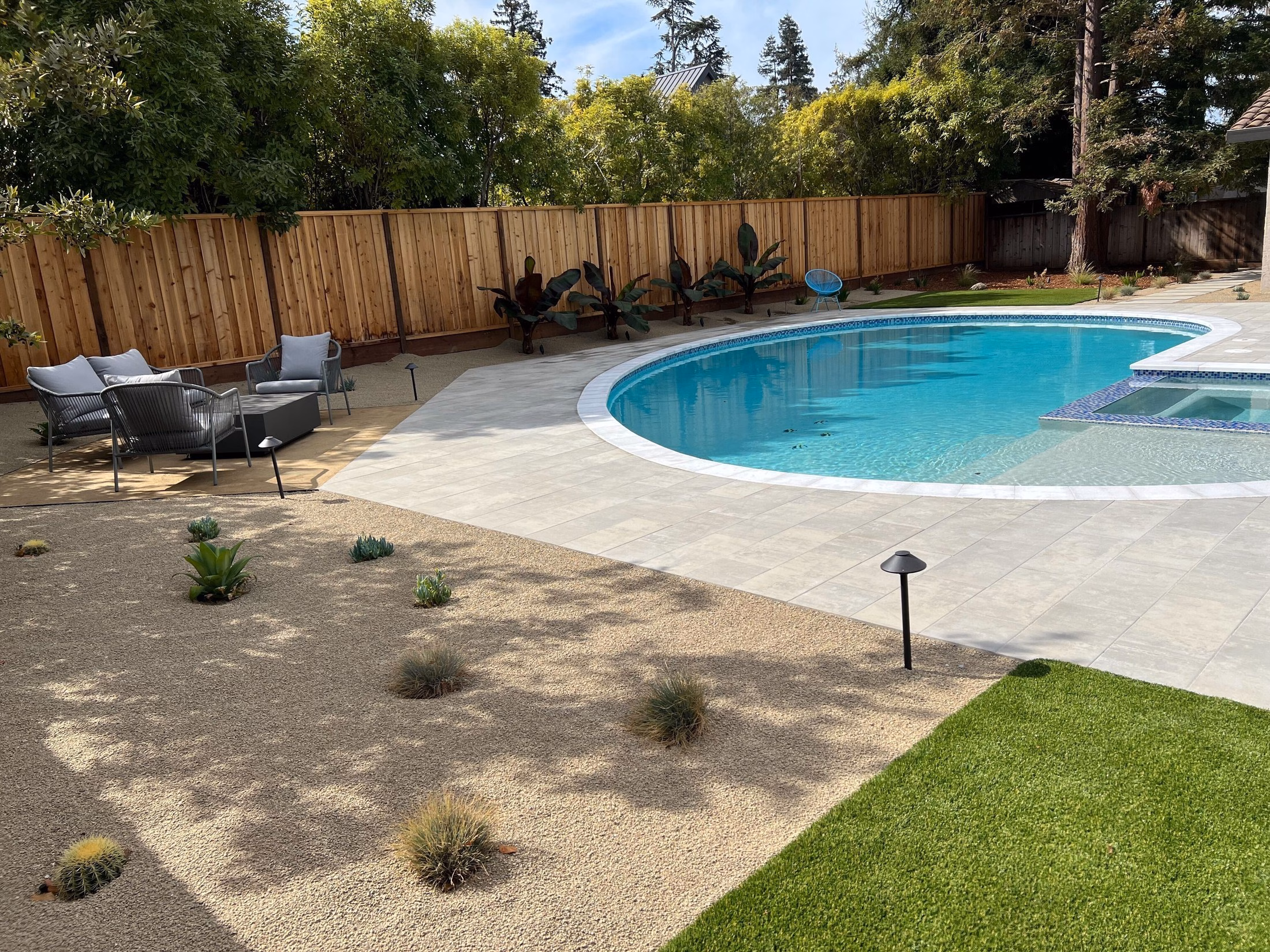 Renovated kidney pool with new Belgard Dimensions paver deck, synthetic turf lawn and pea gravel lounge corner in Los Altos, CA