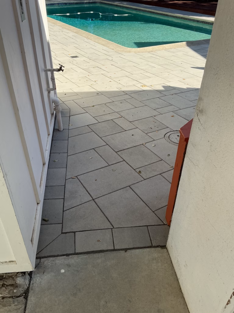 After — light gray pavers running through the side passage toward the pool