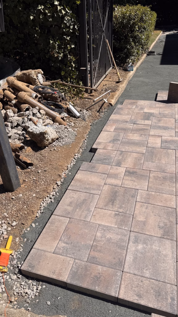 First rows of driveway pavers laid inside the street gate